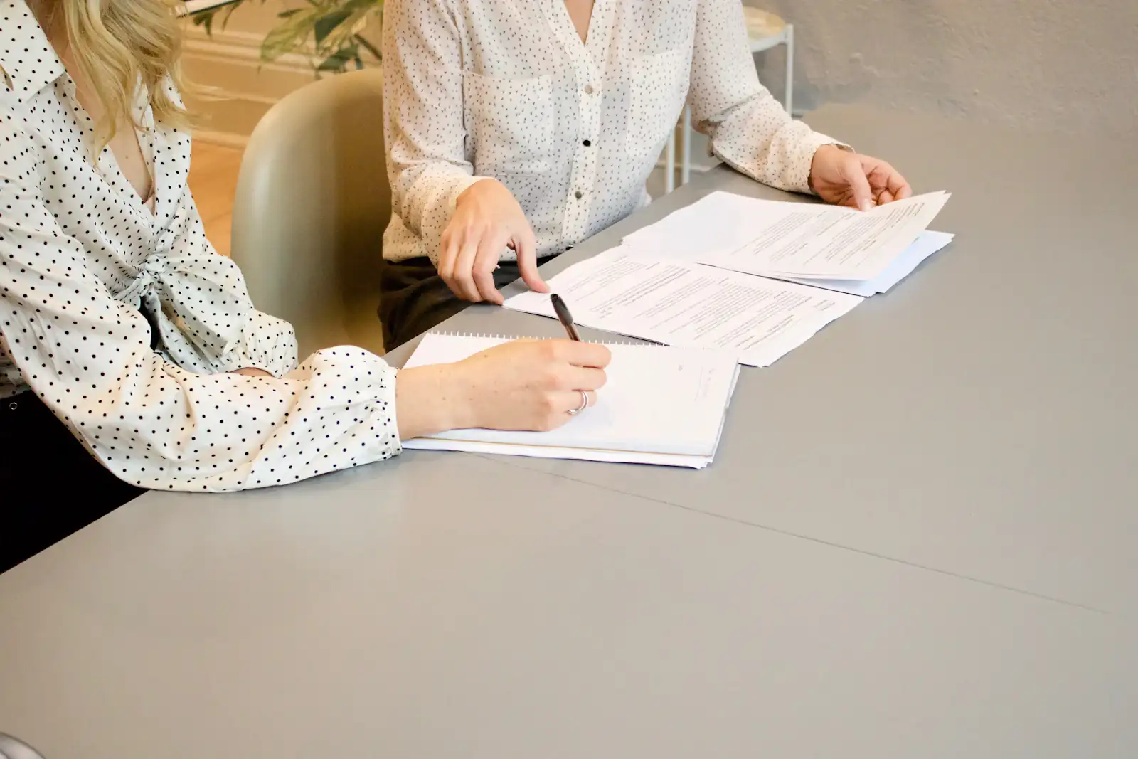 Two people signing papers at a table