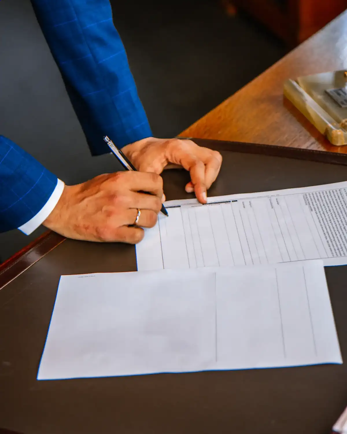 Man in a suit signing a document